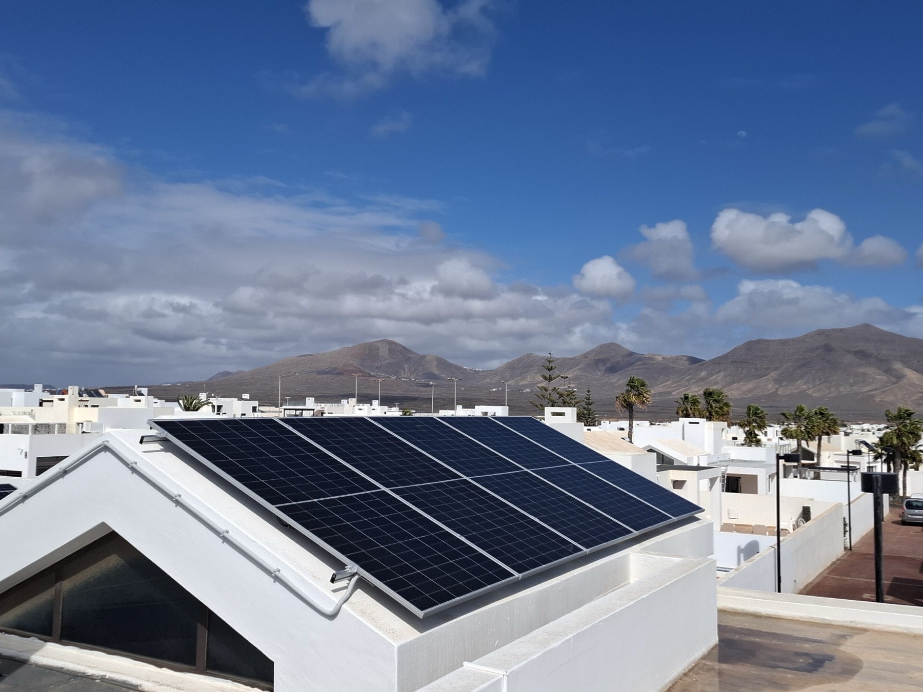 Premium solar installation on a villa rooftop with the volcanic mountains of Lanzarote behind