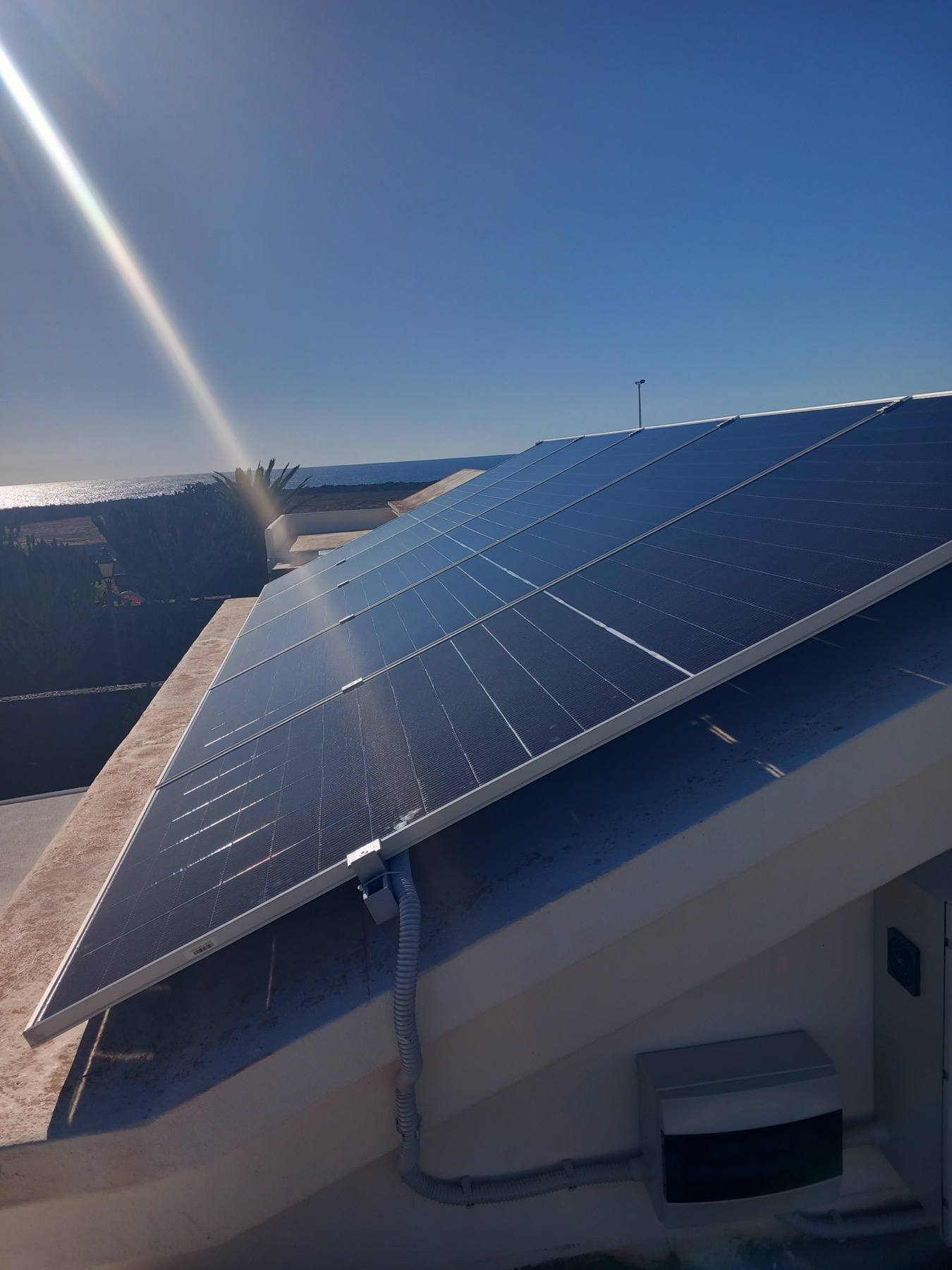 Solar panels on a Lanzarote villa rooftop catching the sun with ocean views