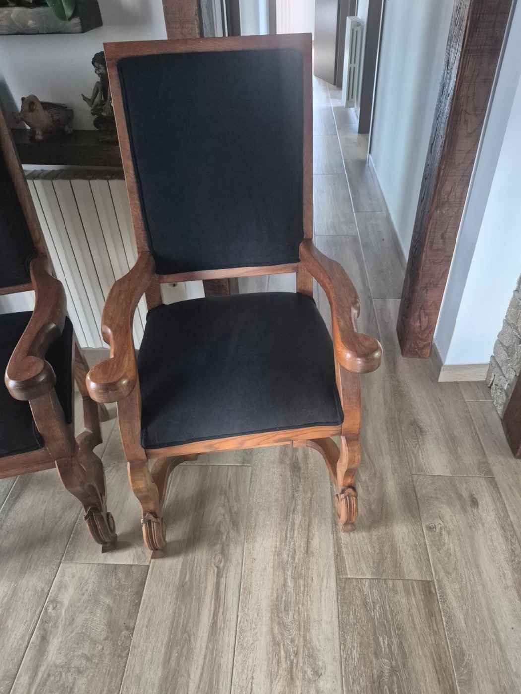 Sillón de madera con asiento y respaldo tapizados en negro