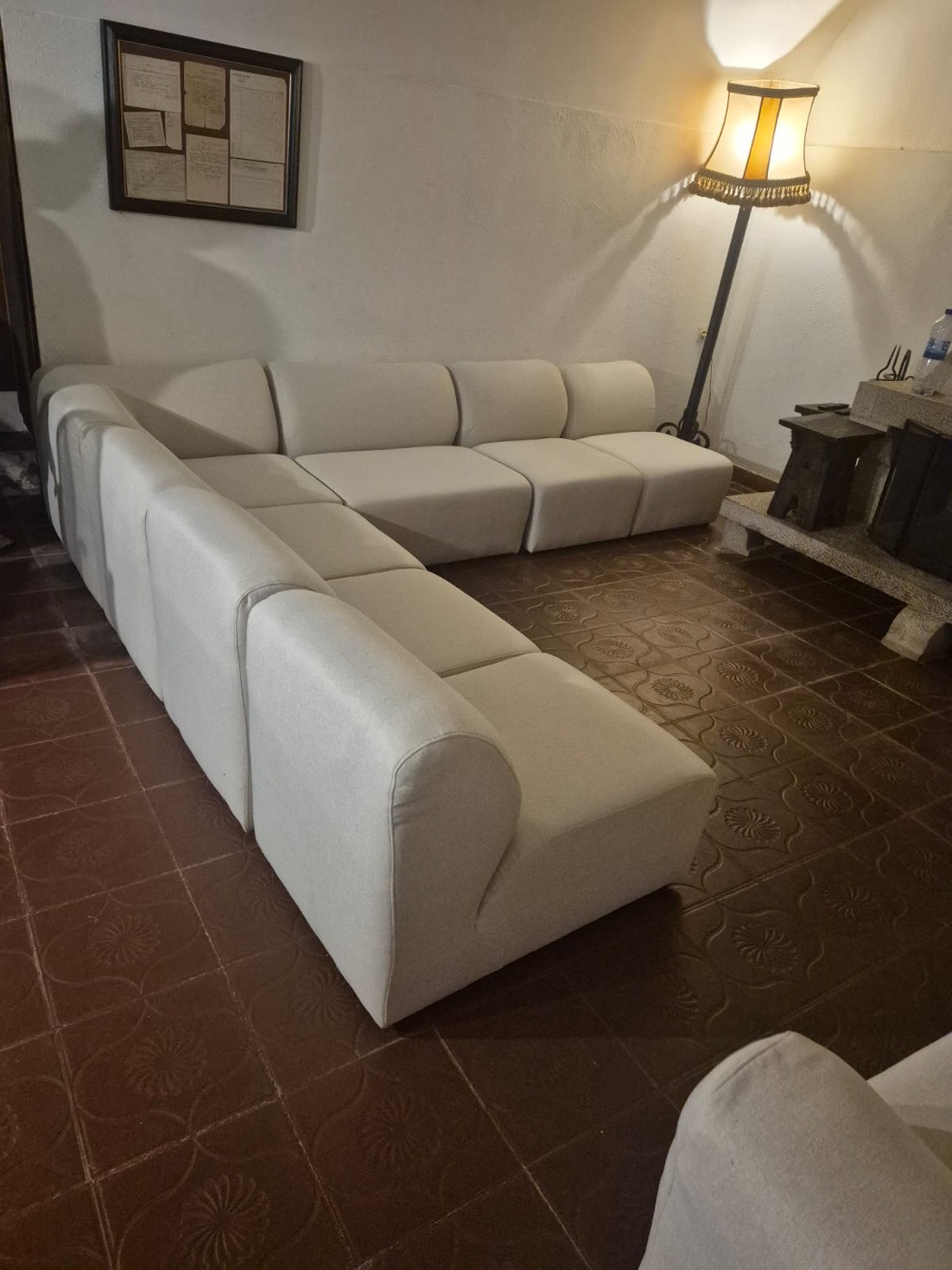 Sofá modular tapizado en tela beige en un salón de Girona